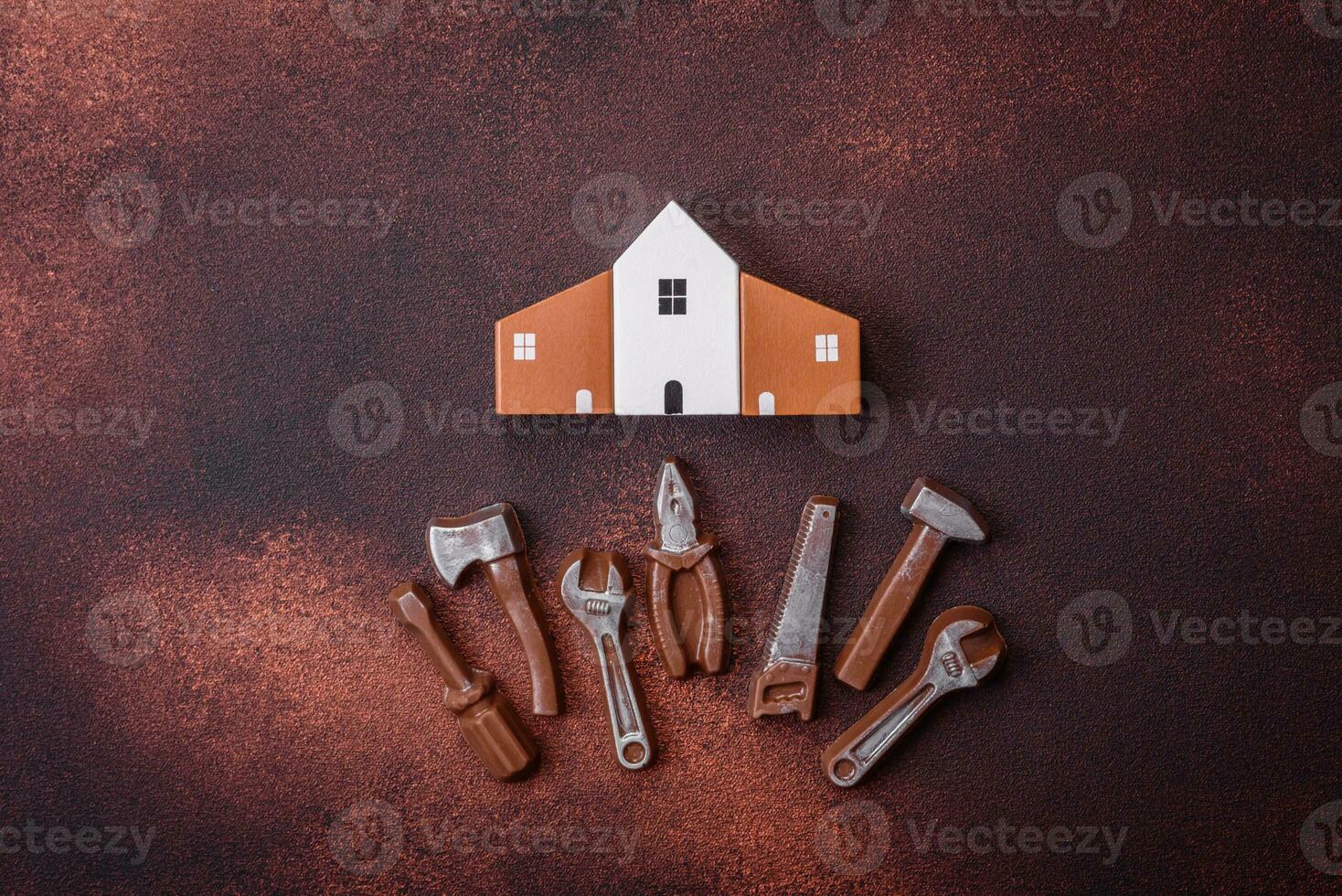 Repair or home improvement tools and a house model on a plain background photo