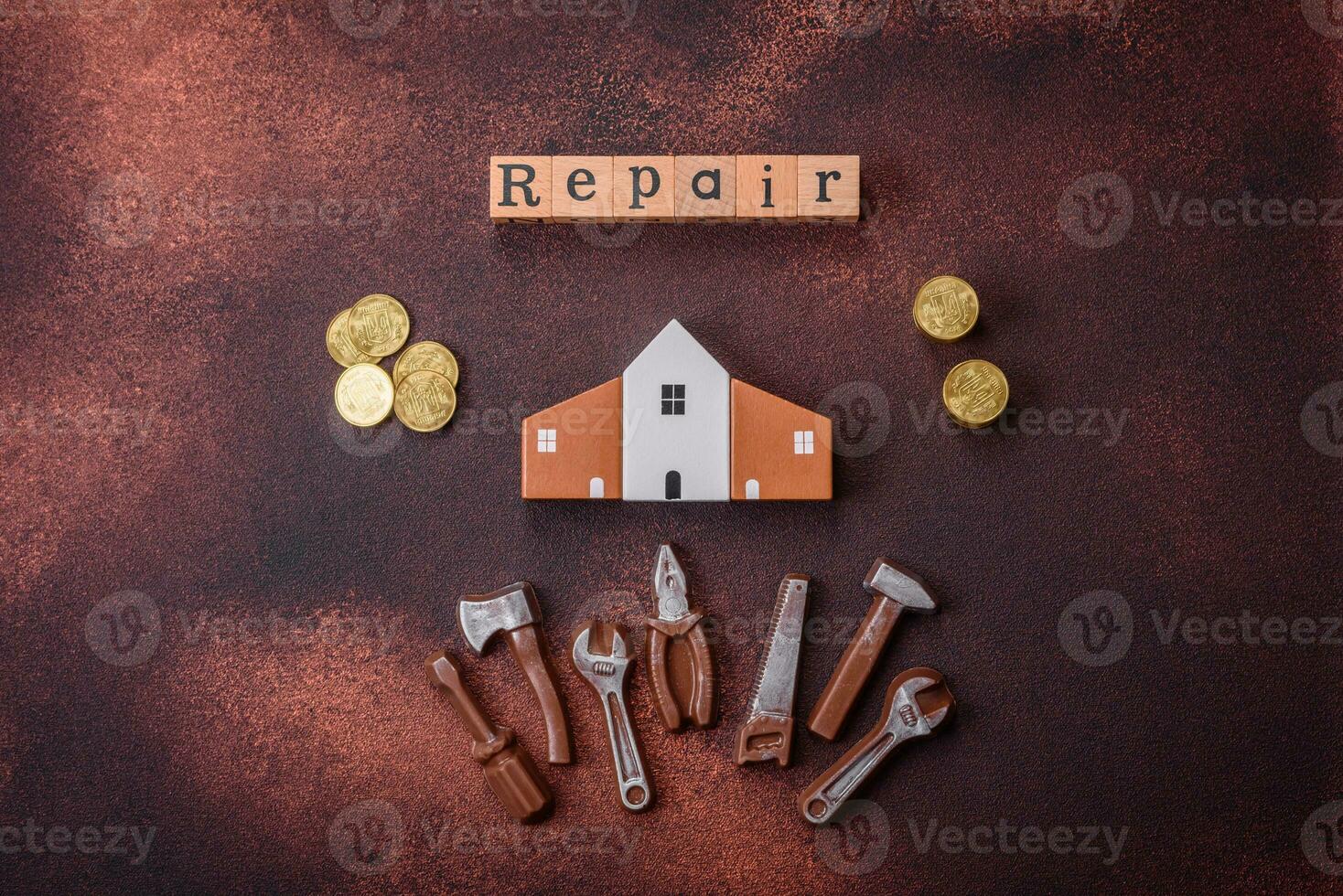 Repair or home improvement tools and a house model on a plain background photo