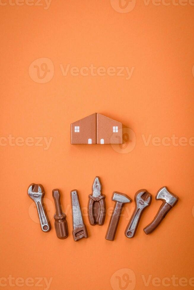 Repair or home improvement tools and a house model on a plain background photo