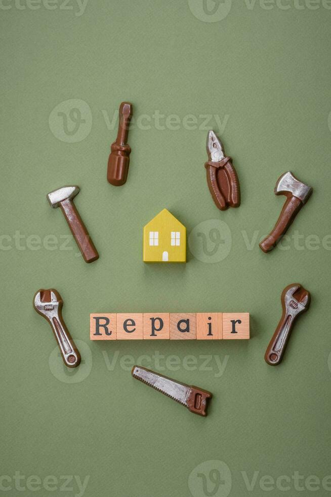 Repair or home improvement tools and a house model on a plain background photo