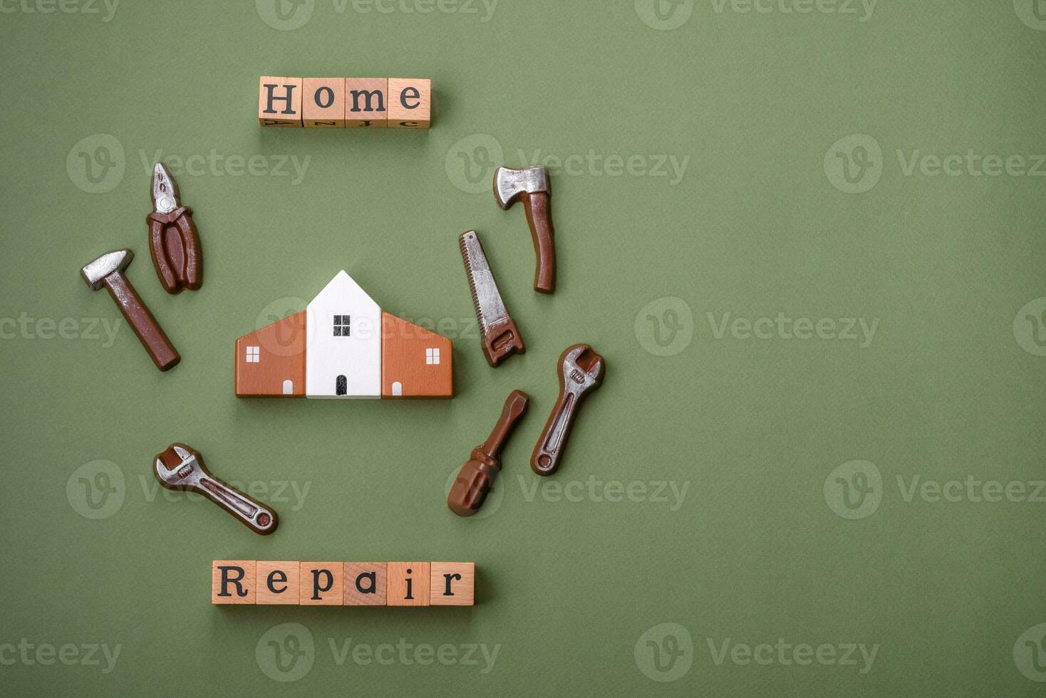 Repair or home improvement tools and a house model on a plain background photo