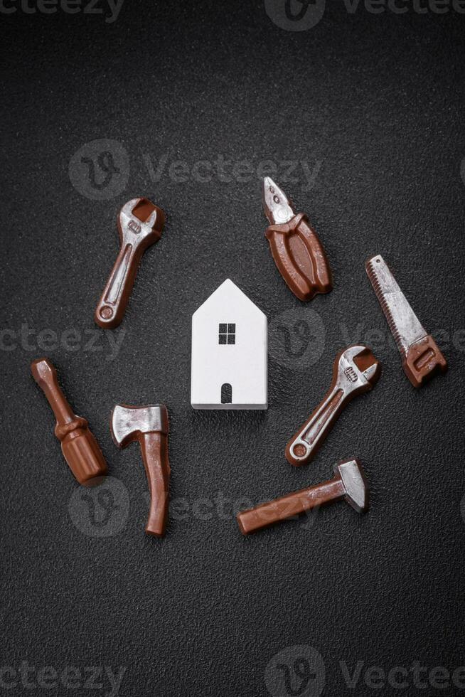 Repair or home improvement tools and a house model on a plain background photo