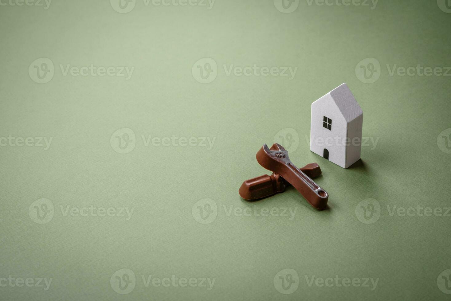 Repair or home improvement tools and a house model on a plain background photo