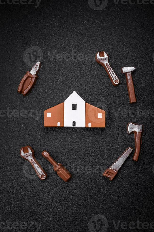 Repair or home improvement tools and a house model on a plain background photo