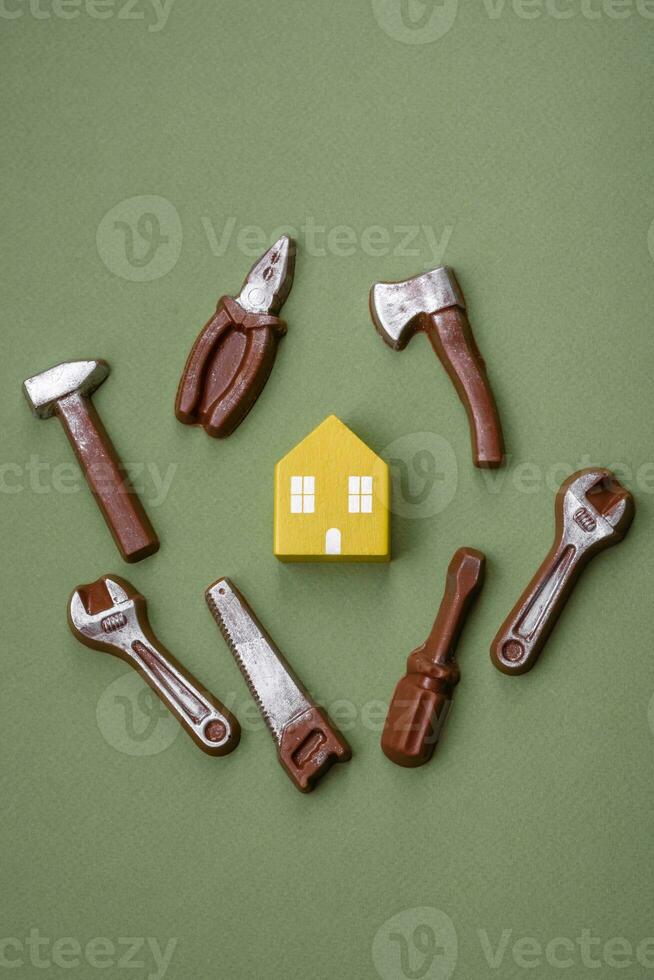 Repair or home improvement tools and a house model on a plain background photo