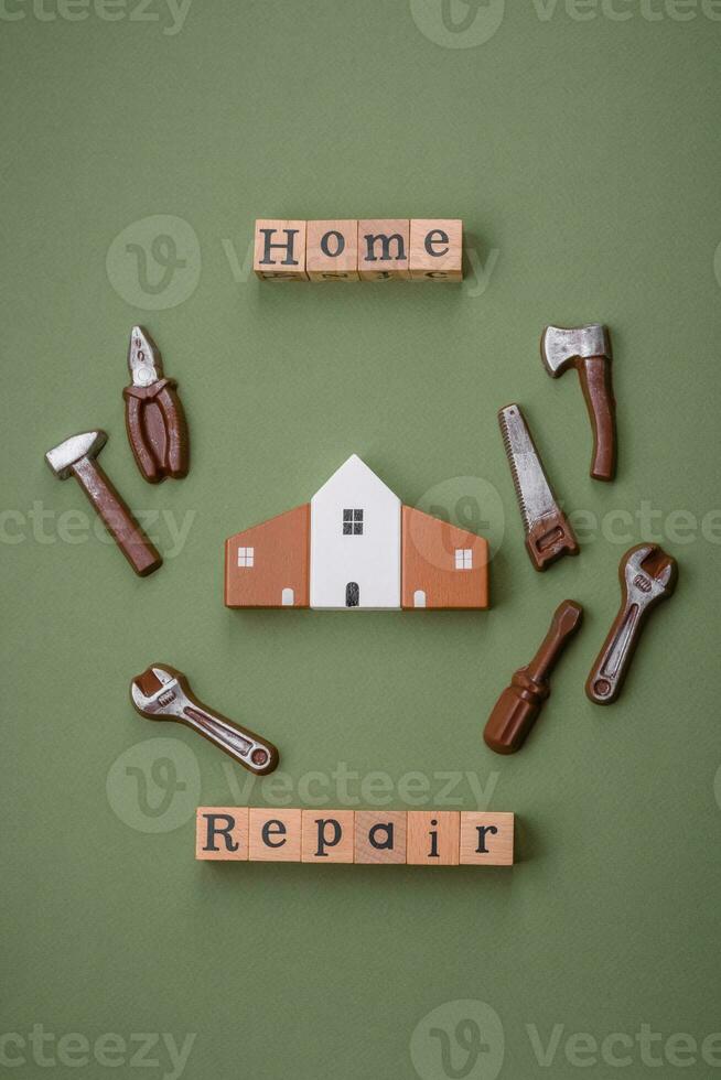 Repair or home improvement tools and a house model on a plain background photo