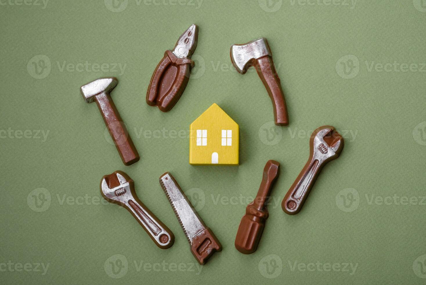 Repair or home improvement tools and a house model on a plain background photo