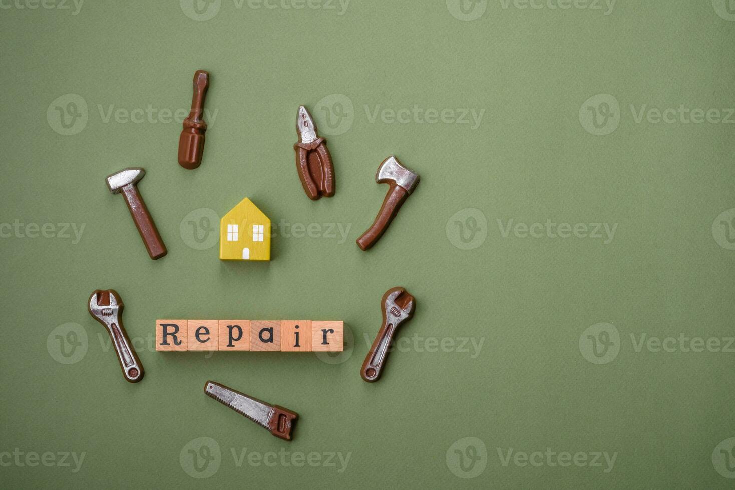 Repair or home improvement tools and a house model on a plain background photo