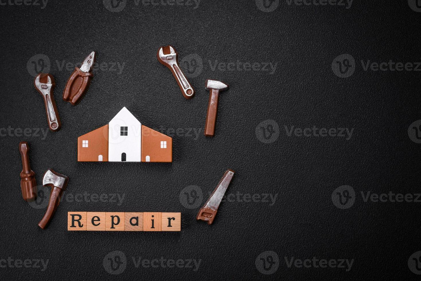 Repair or home improvement tools and a house model on a plain background photo