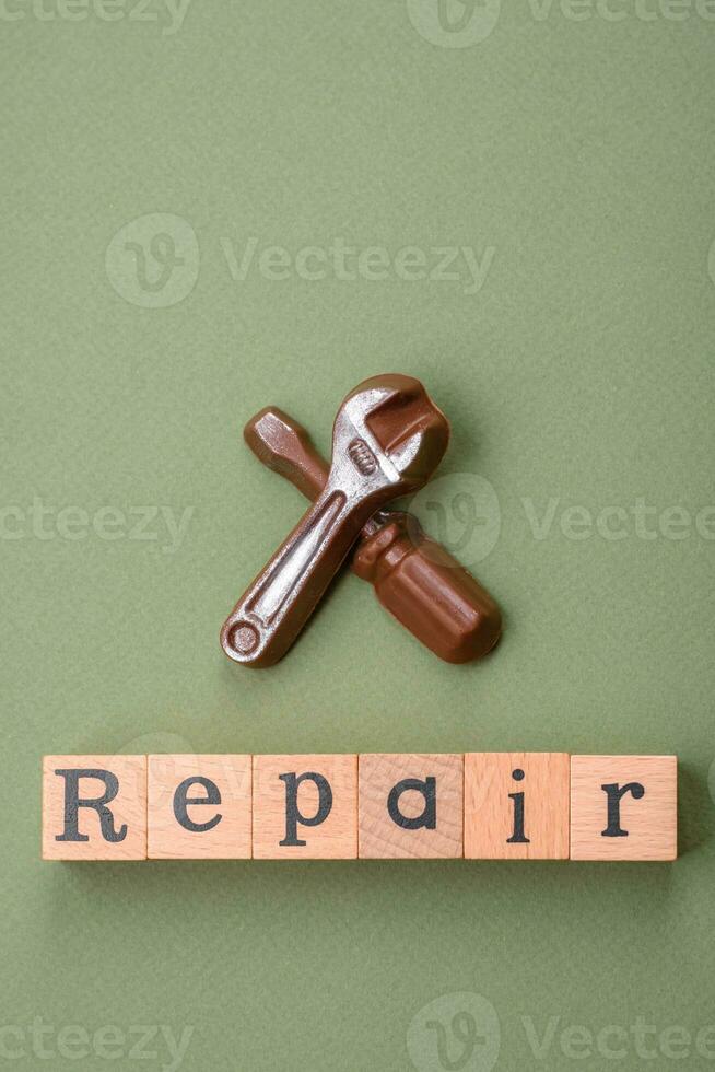 Tools and inscriptions symbolizing repairs or a garage and its attributes on a plain background photo