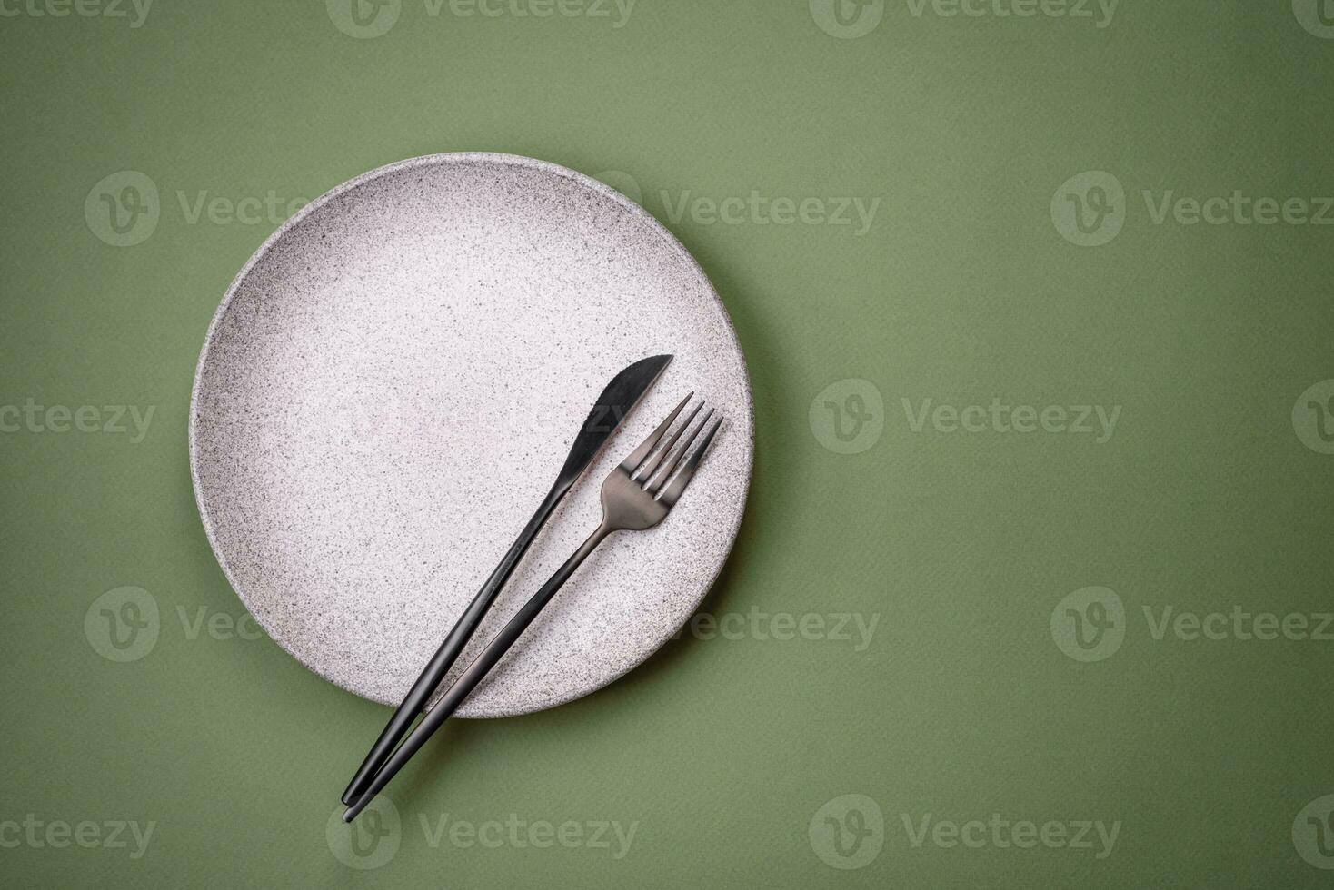 Empty round ceramic plate on a plain background, flatley with copy space photo