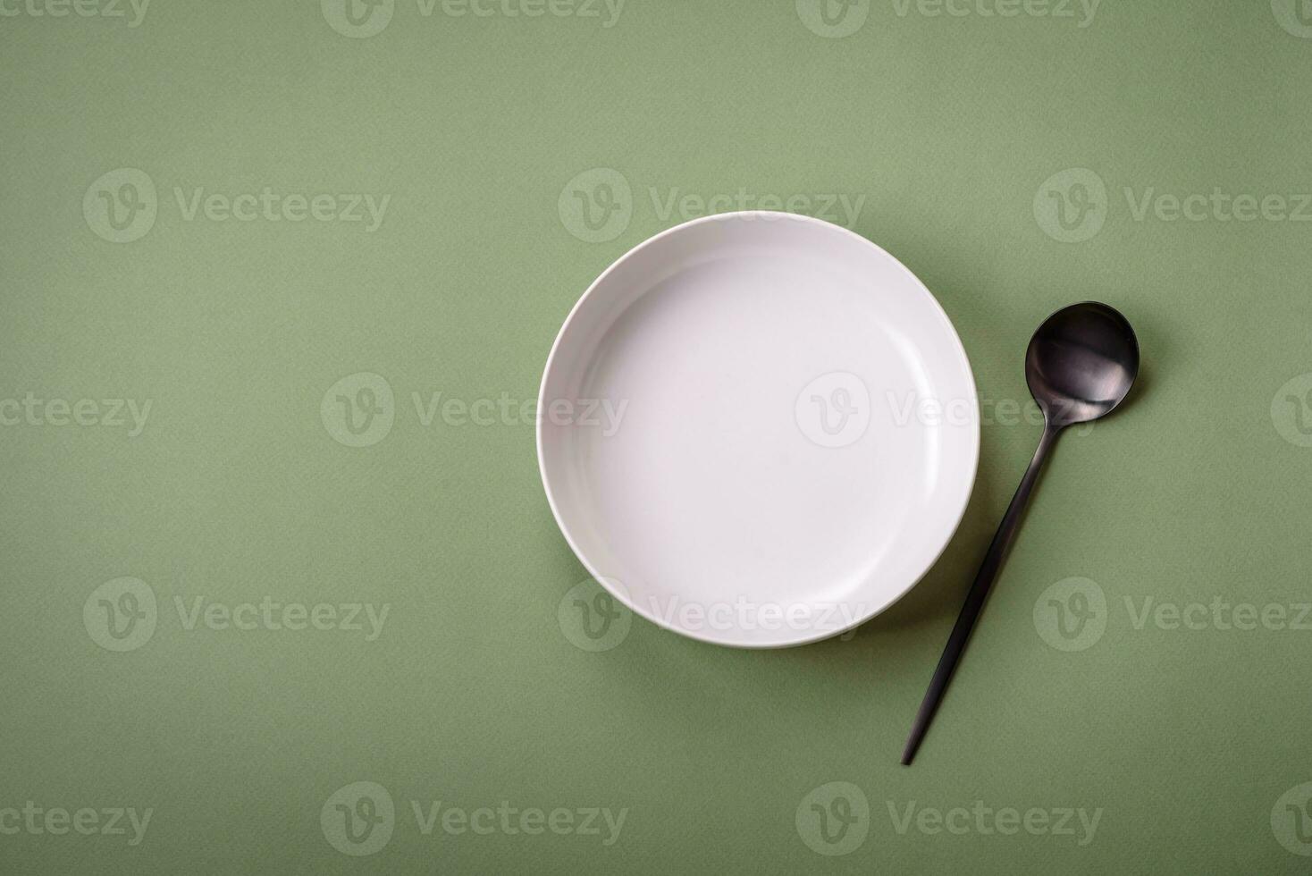 Empty round ceramic plate on a plain background, flatley with copy space photo