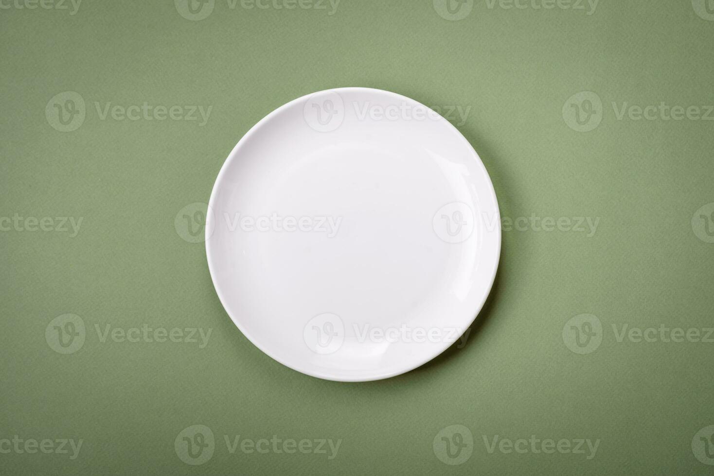 Empty round ceramic plate on a plain background, flatley with copy space photo