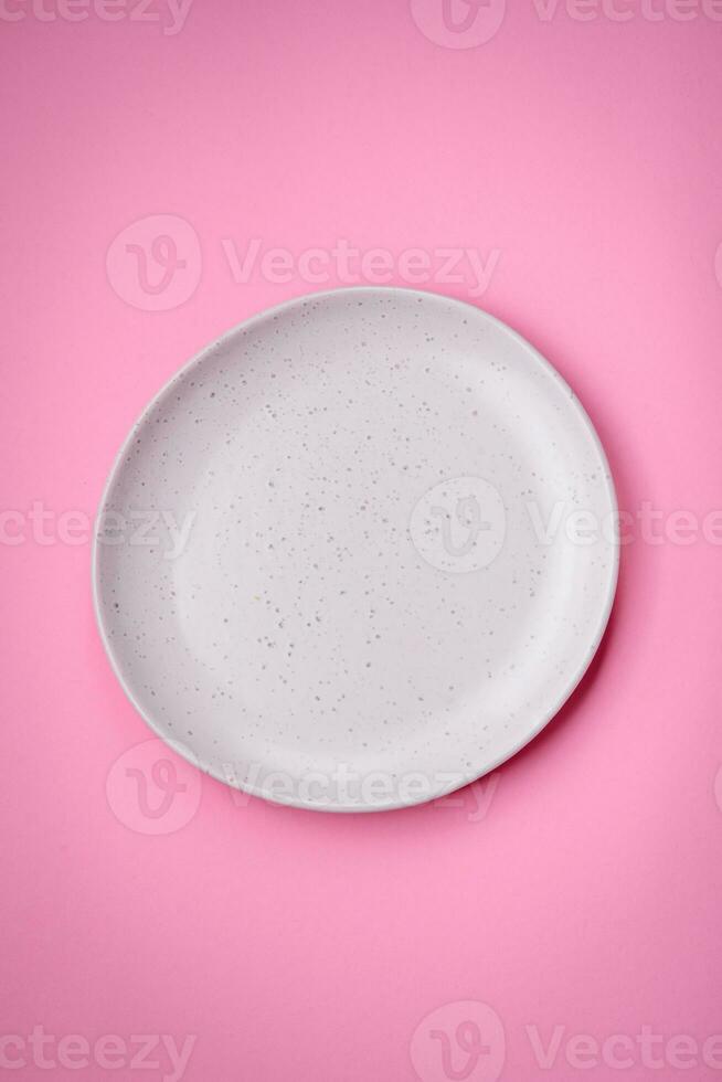 Empty round ceramic plate on a plain background, flatley with copy space photo