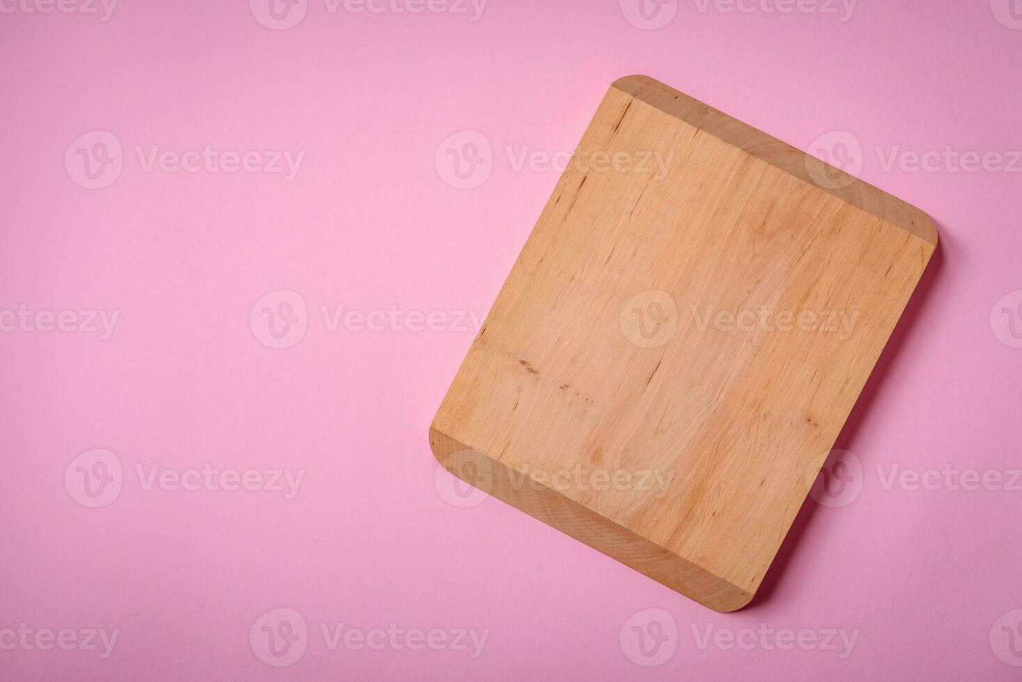 Empty wooden rectangular cutting board on a plain background, flatley with copy space photo