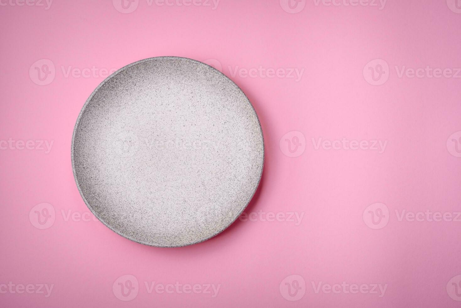 Empty round ceramic plate on a plain background, flatley with copy space photo