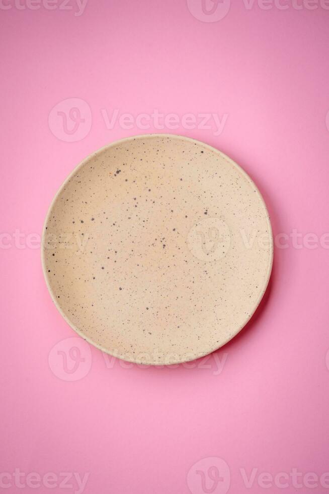 Empty round ceramic plate on a plain background, flatley with copy space photo