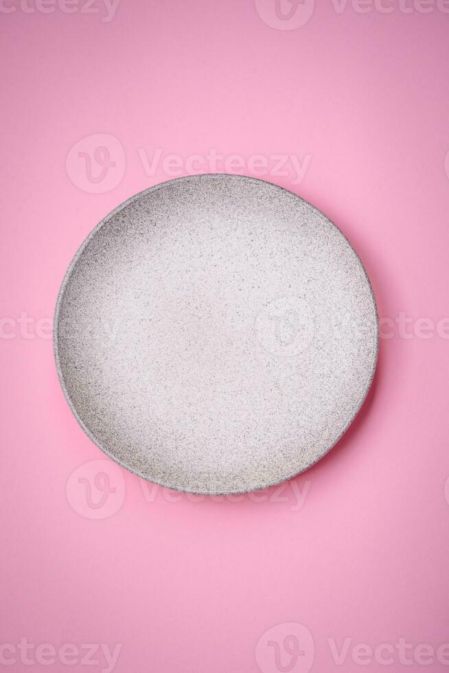 Empty round ceramic plate on a plain background, flatley with copy space photo