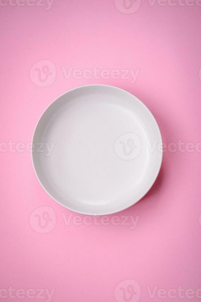 Empty round ceramic plate on a plain background, flatley with copy space photo