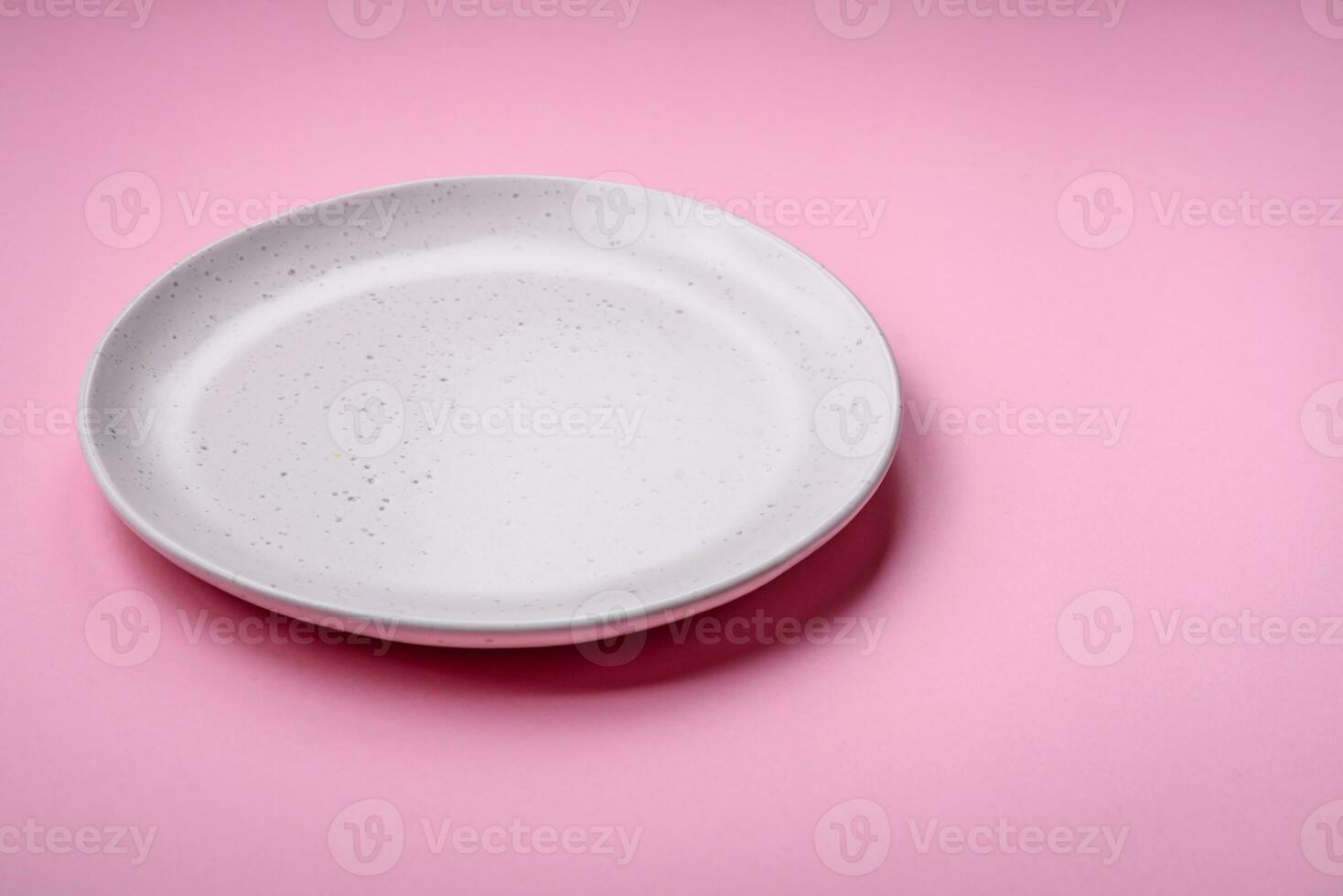 Empty round ceramic plate on a plain background, flatley with copy space photo