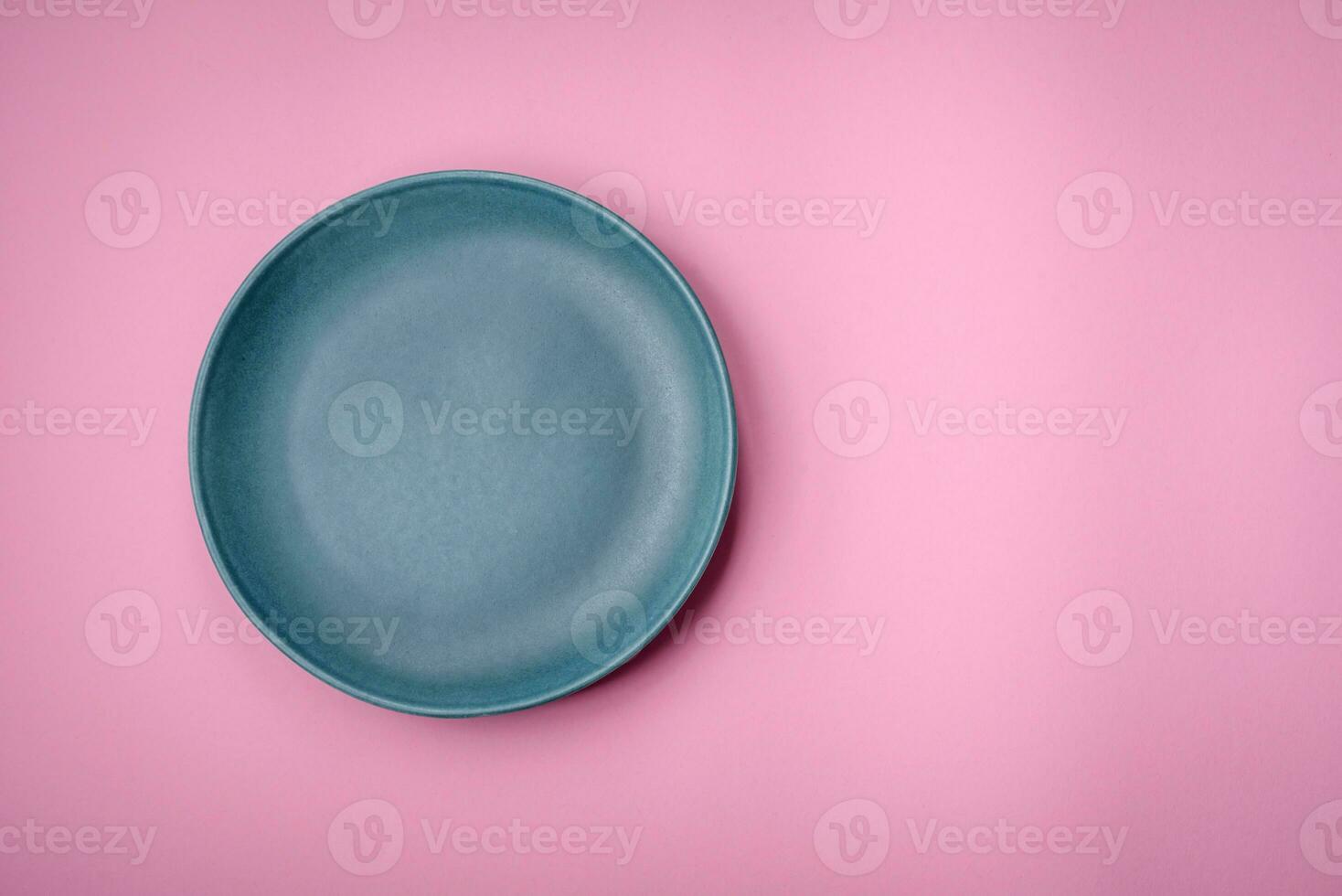 Empty round ceramic plate on a plain background, flatley with copy space photo