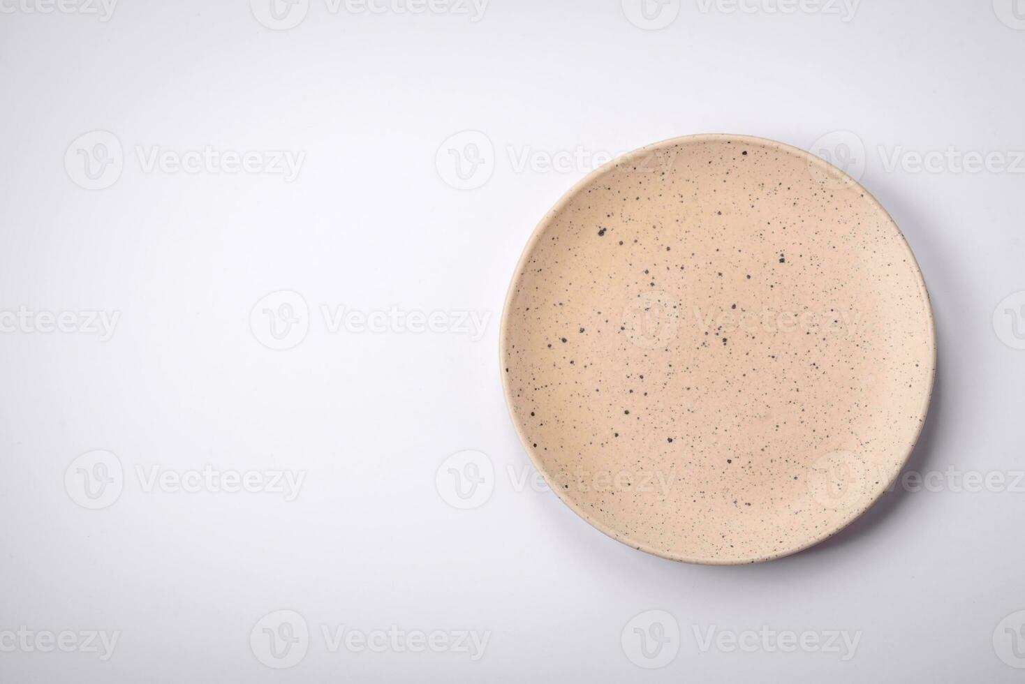 Empty round ceramic plate on a plain background, flatley with copy space photo
