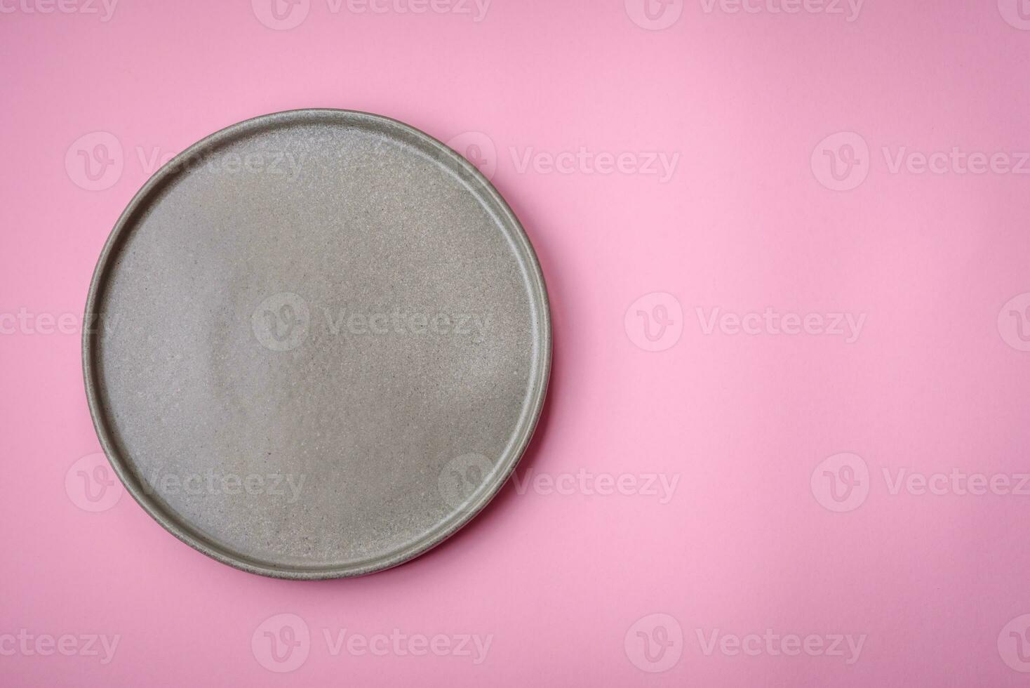 Empty round ceramic plate on a plain background, flatley with copy space photo