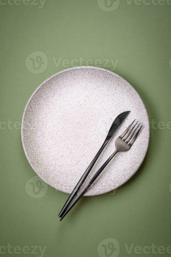 Empty round ceramic plate on a plain background, flatley with copy space photo