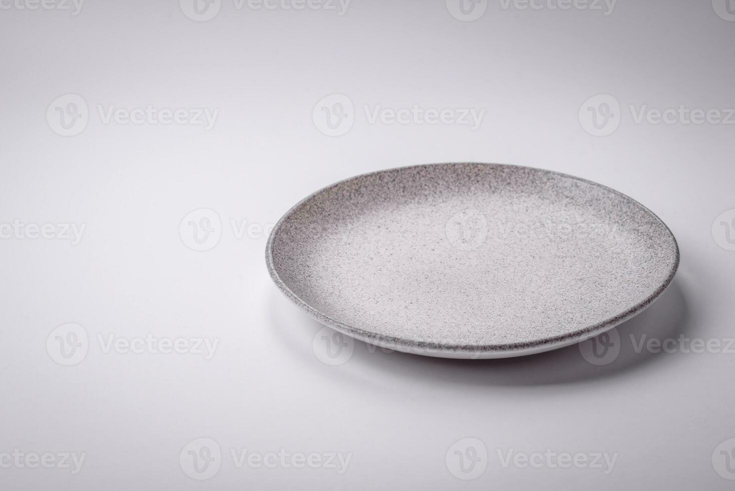 Empty round ceramic plate on a plain background, flatley with copy space photo