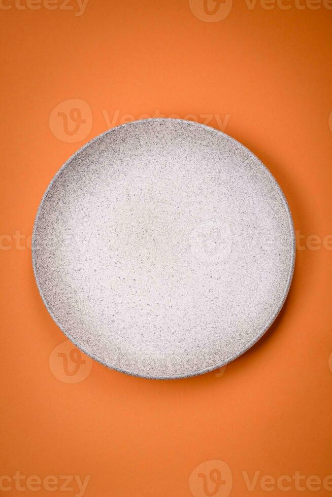 Empty round ceramic plate on a plain background, flatley with copy space photo