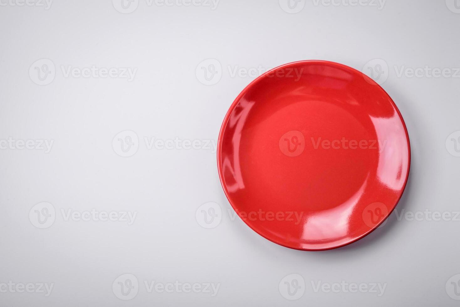 Empty round ceramic plate on a plain background, flatley with copy space photo