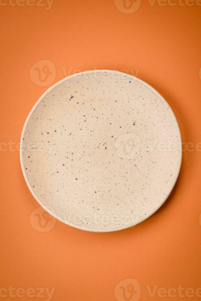 Empty round ceramic plate on a plain background, flatley with copy space photo