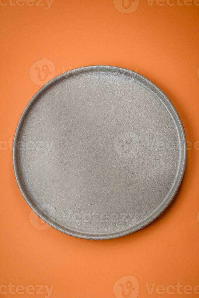 Empty round ceramic plate on a plain background, flatley with copy space photo