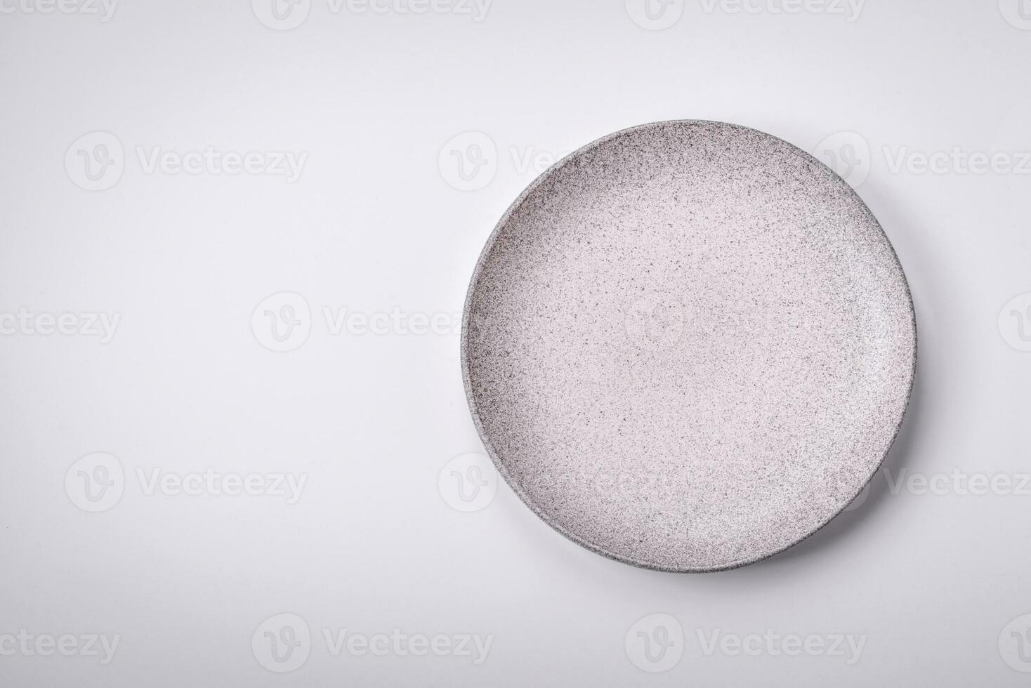 Empty round ceramic plate on a plain background, flatley with copy space photo