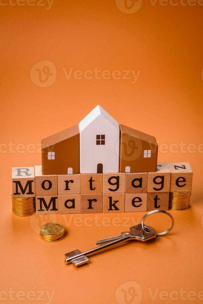 A small wooden house and keys as an idea for investing in your own home photo