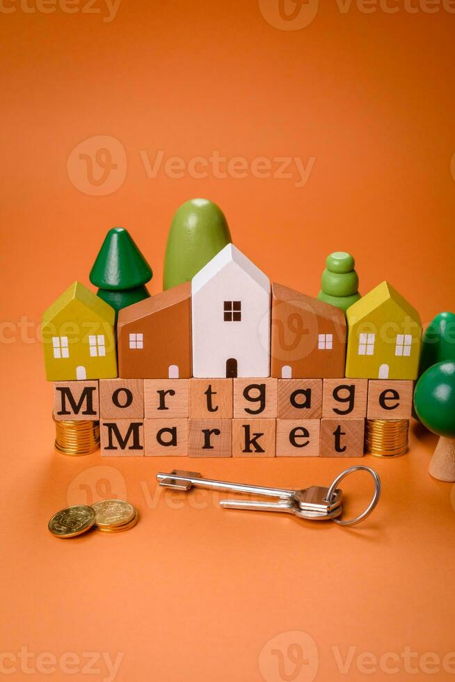 A small wooden house and keys as an idea for investing in your own home photo