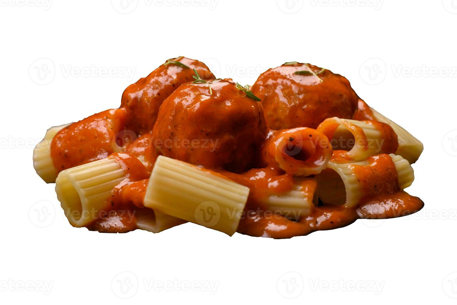 Delicious fresh meatballs and pasta in tomato sauce with salt, spices and herbs photo