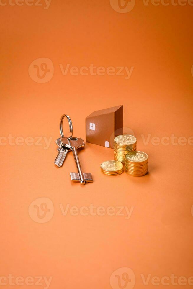 A small wooden house, money and keys as an idea for investing in your own home photo