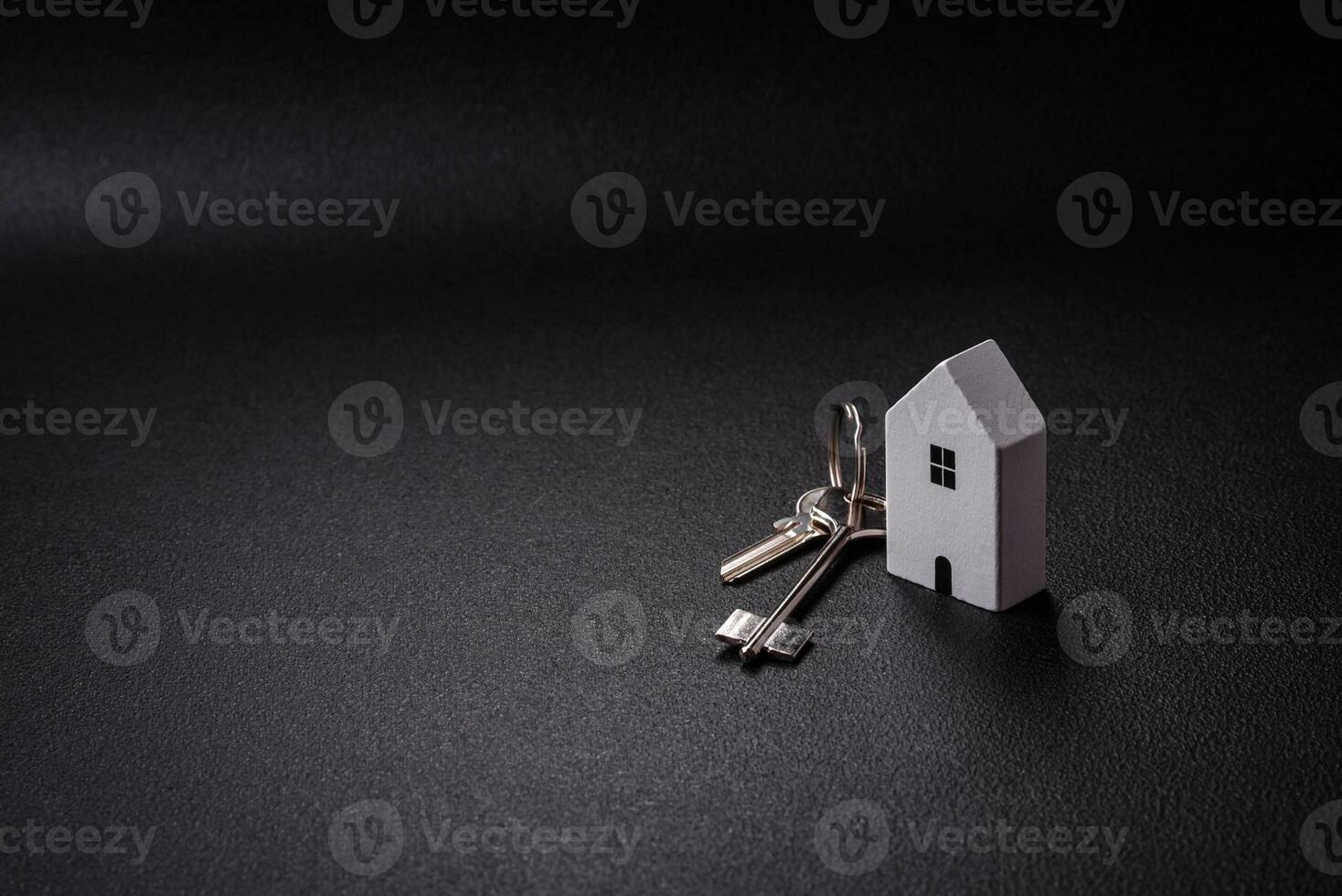 A small wooden house and keys as an idea for investing in your own home and achieving the goal of buying real estate photo