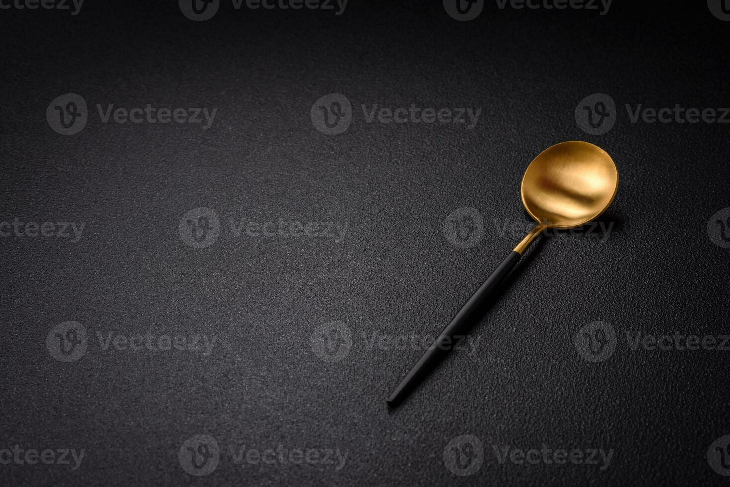 Empty metal spoon on dark textured concrete background photo