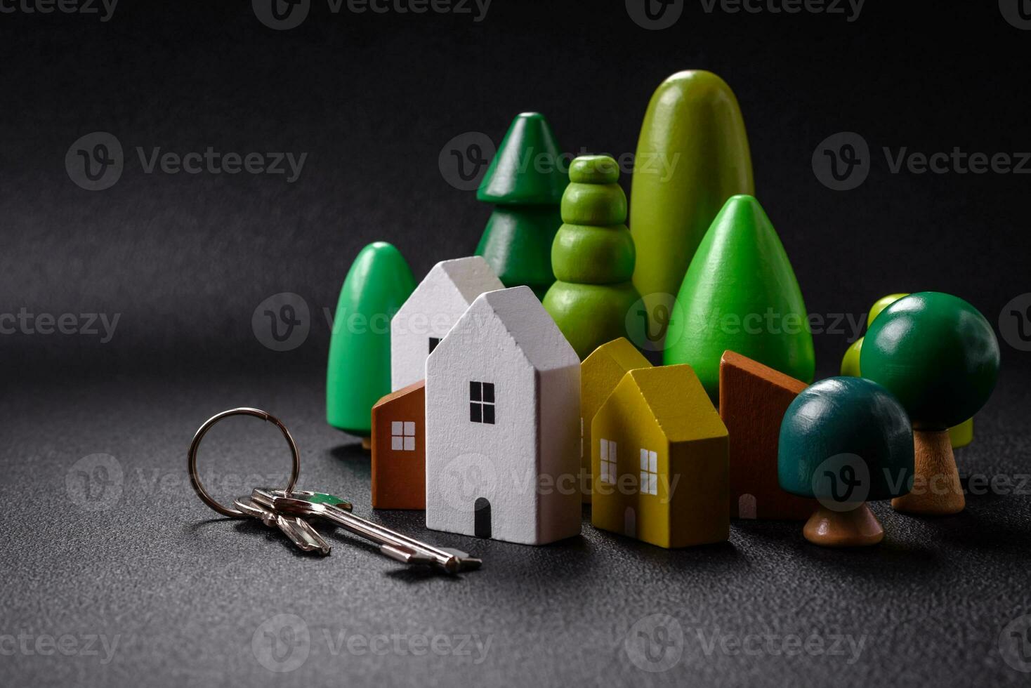 A small wooden house and keys as an idea for investing in your own home and achieving the goal of buying real estate photo