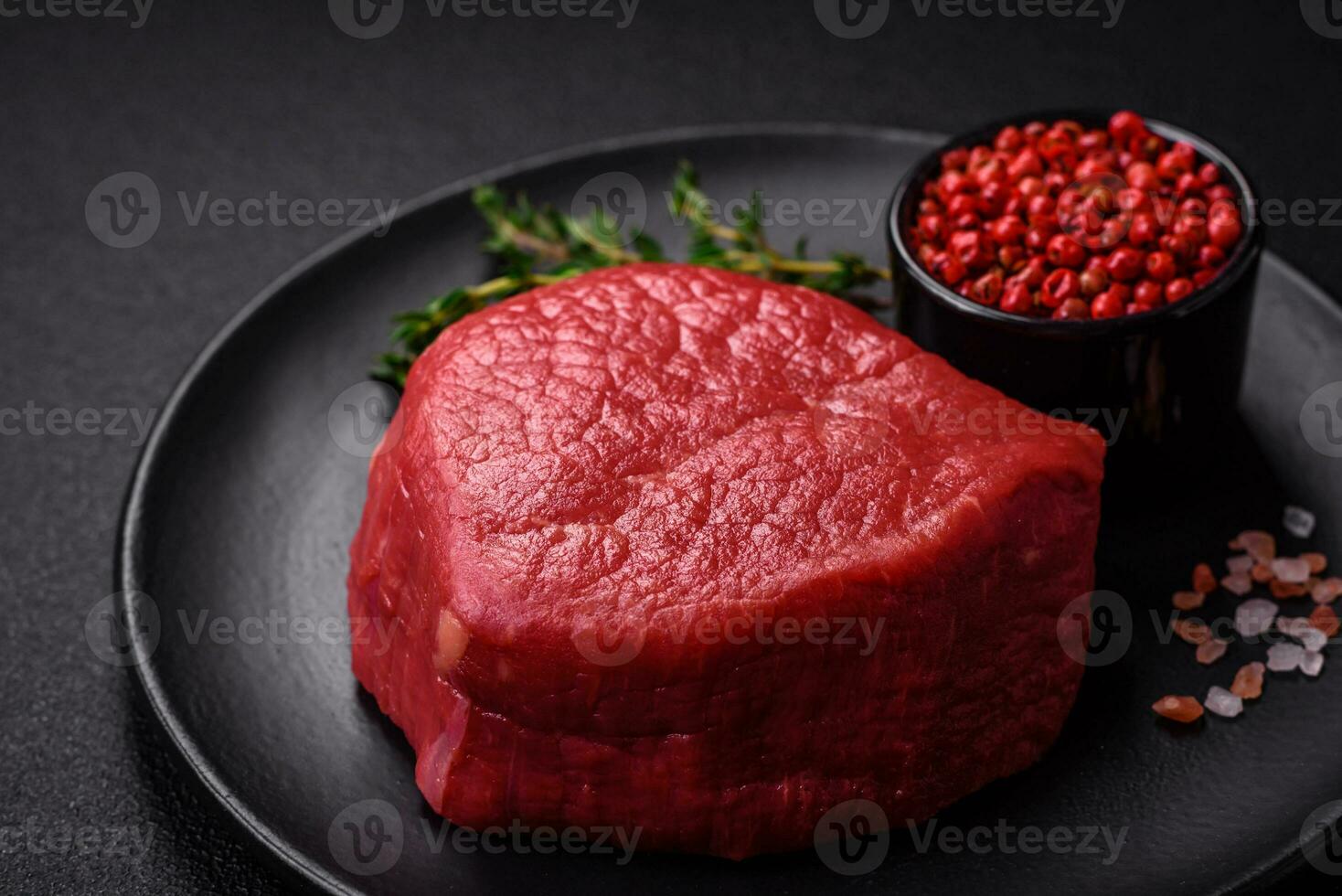 Fresh juicy raw filet mignon with salt, spices and herbs photo