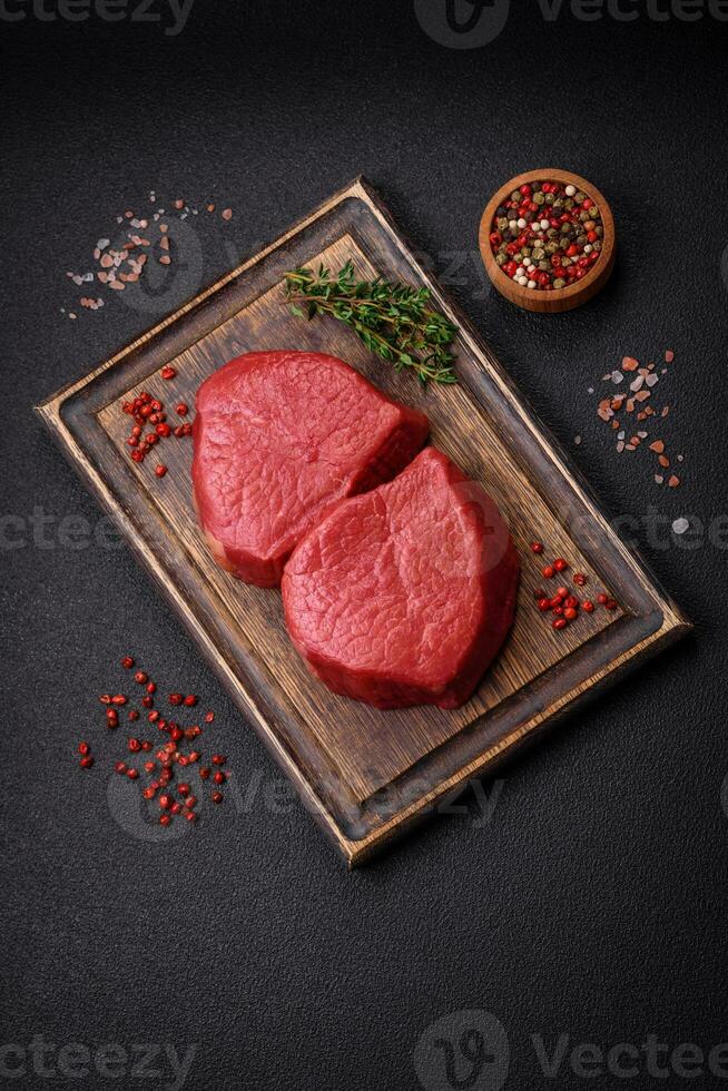Fresh juicy raw filet mignon with salt, spices and herbs photo