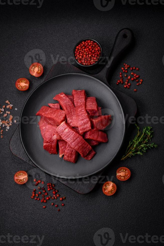 Juicy fresh raw beef meat with salt, spices and herbs photo