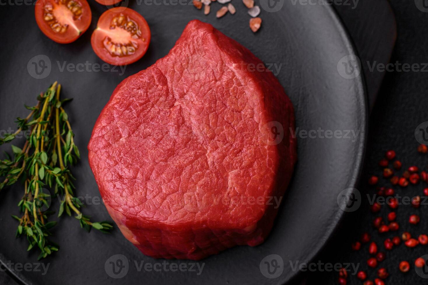 Fresh juicy raw filet mignon with salt, spices and herbs photo