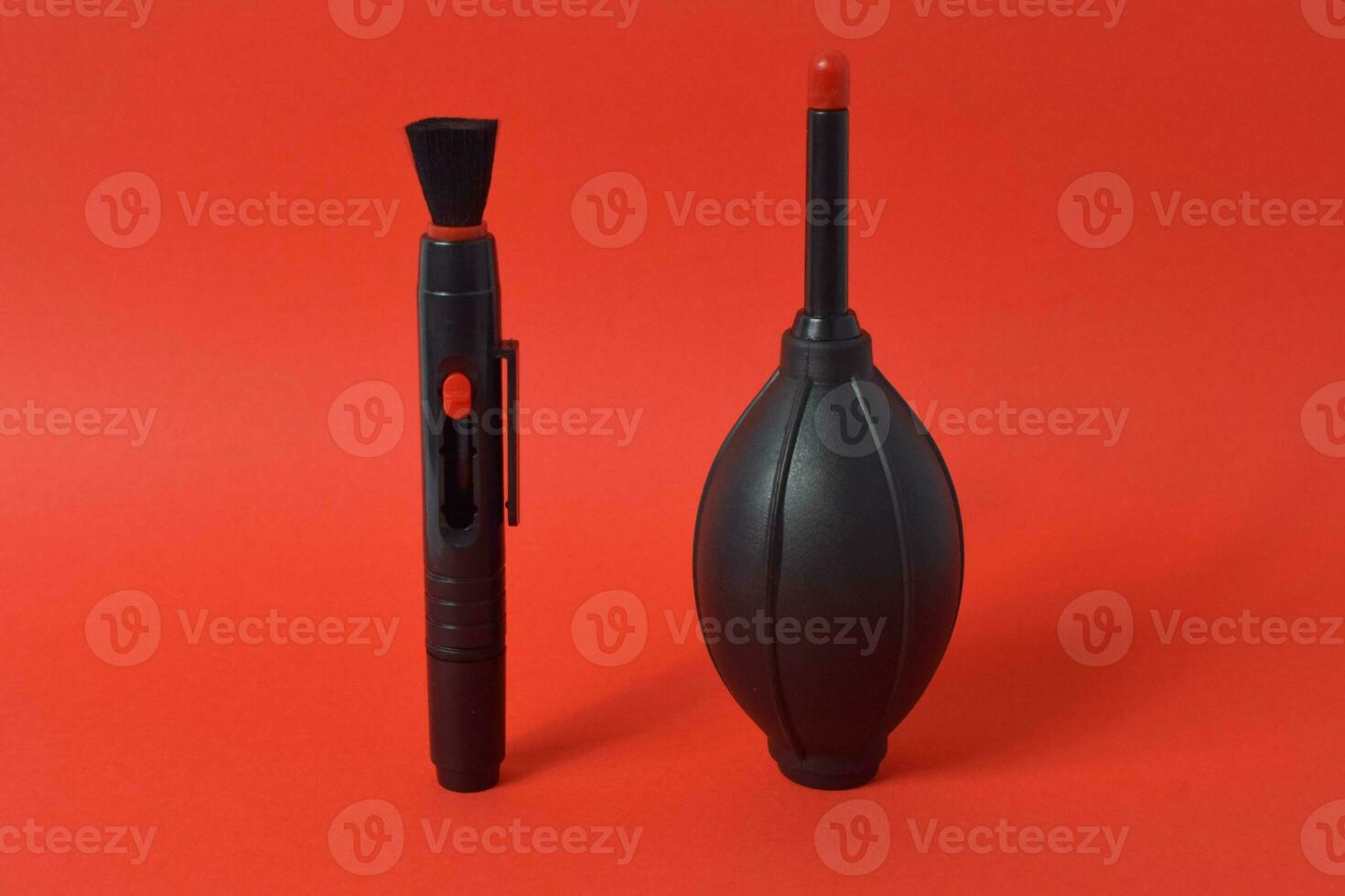 Rubber air blower, brush and lens ceaner isolated on red background, camera cleaning set photo