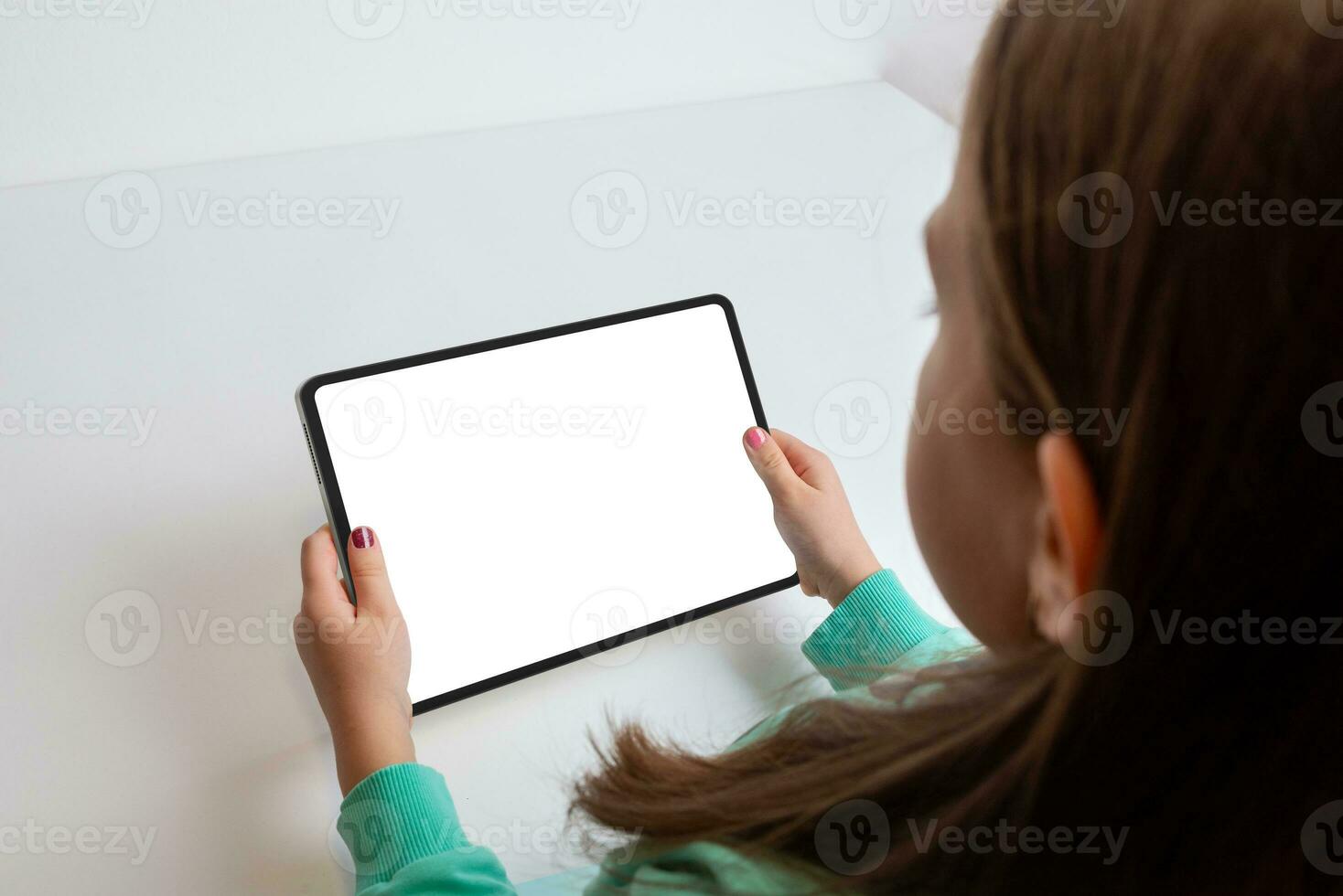 Girl watching a movie on a tablet in a horizontal position at her work desk. Isolated screen for multimedia promotion photo