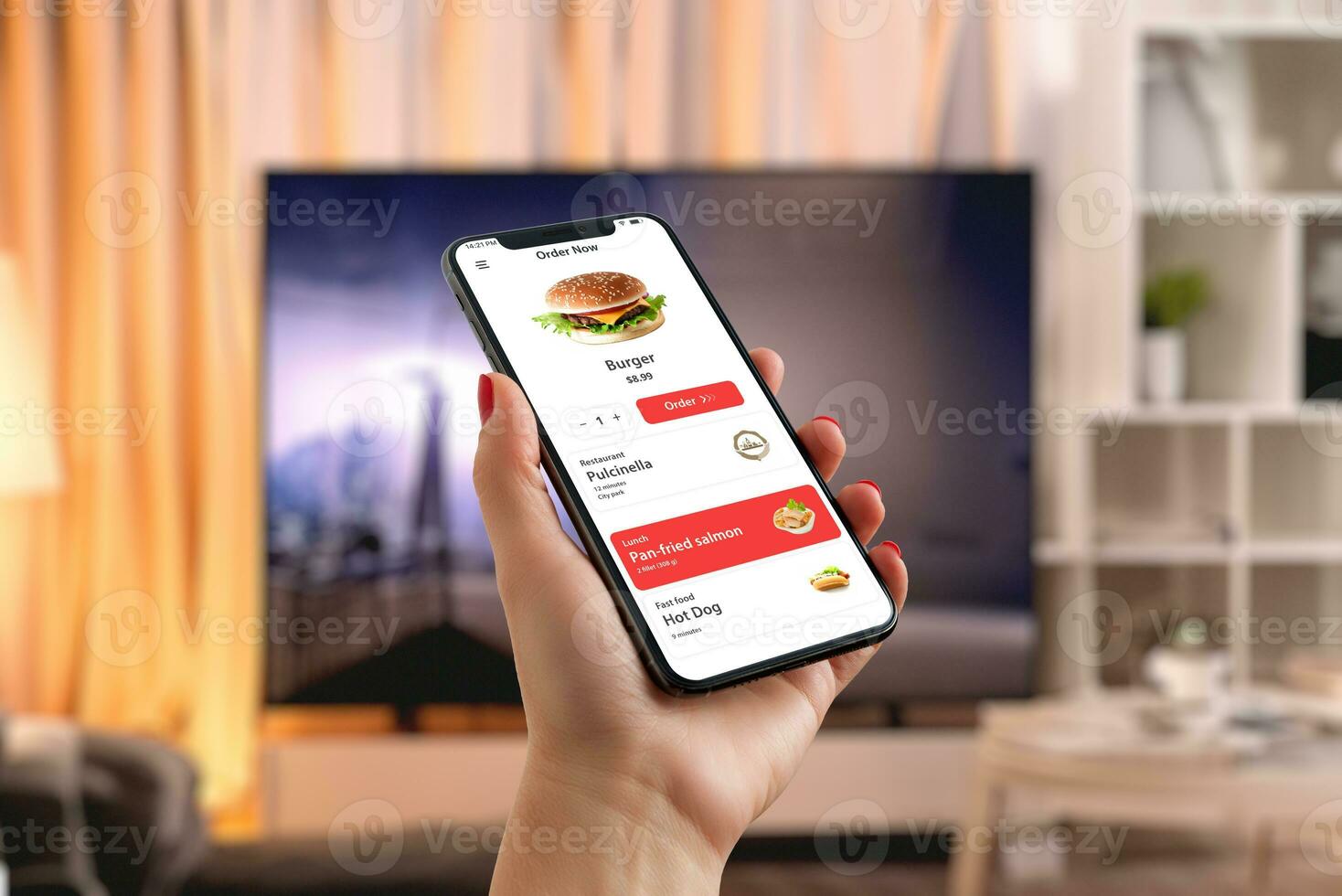 Man orders a burger via smartphone in the living room, creating a perfect blend of tech convenience and enjoyment in fast food in front of the TV photo