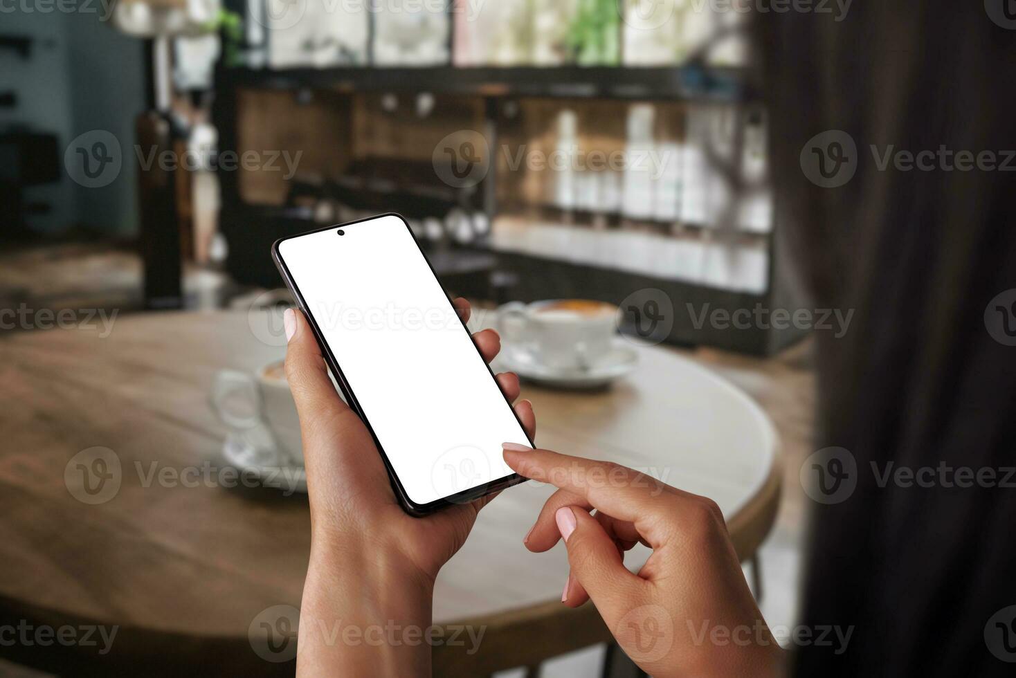 Woman working on phone mockup in a cozy coffee shop, embodying the concept of relaxing free time. Using the phone for communication, blending work and leisure effortlessly photo