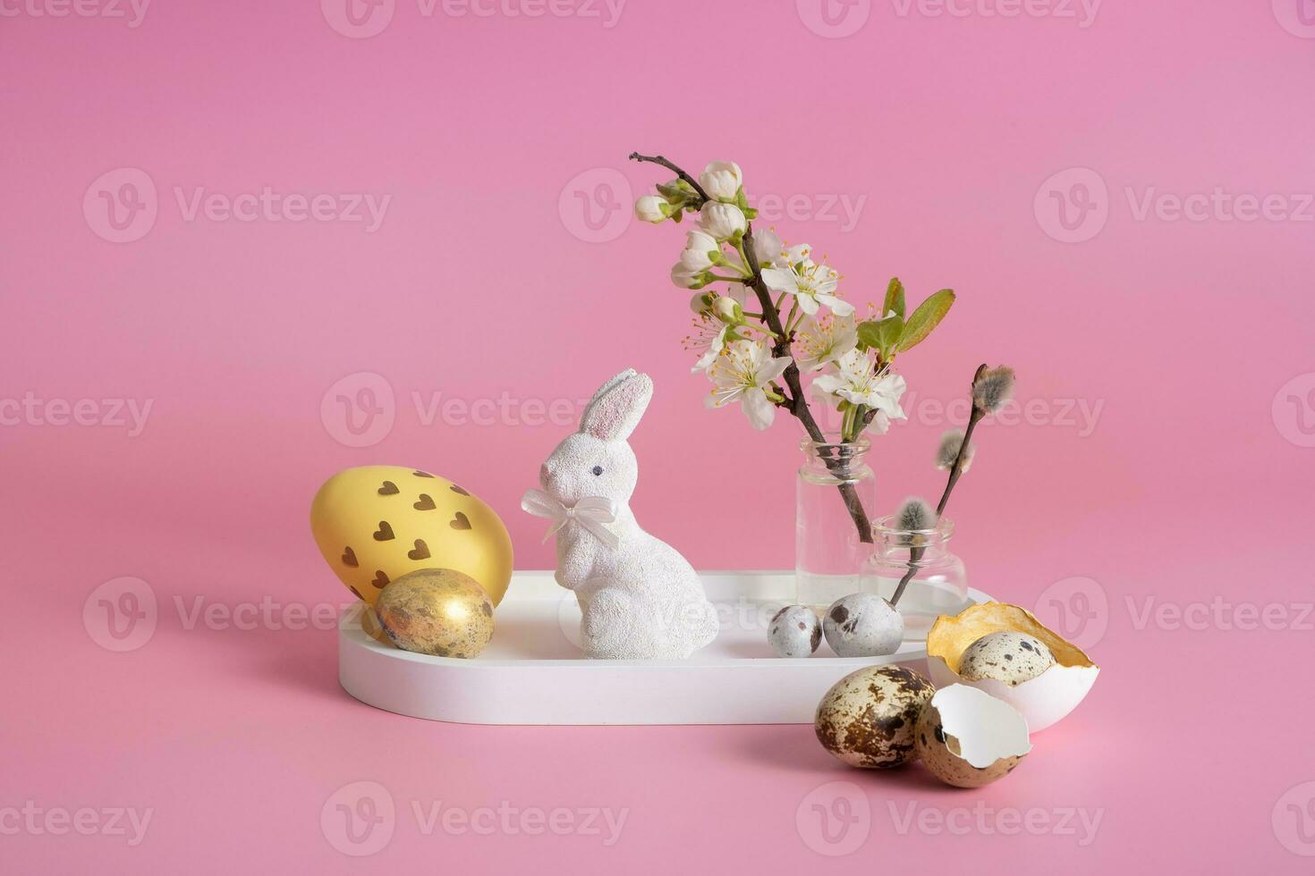 White rabbit, blossom twig and Easter eggs on a pink background. Easter composition photo